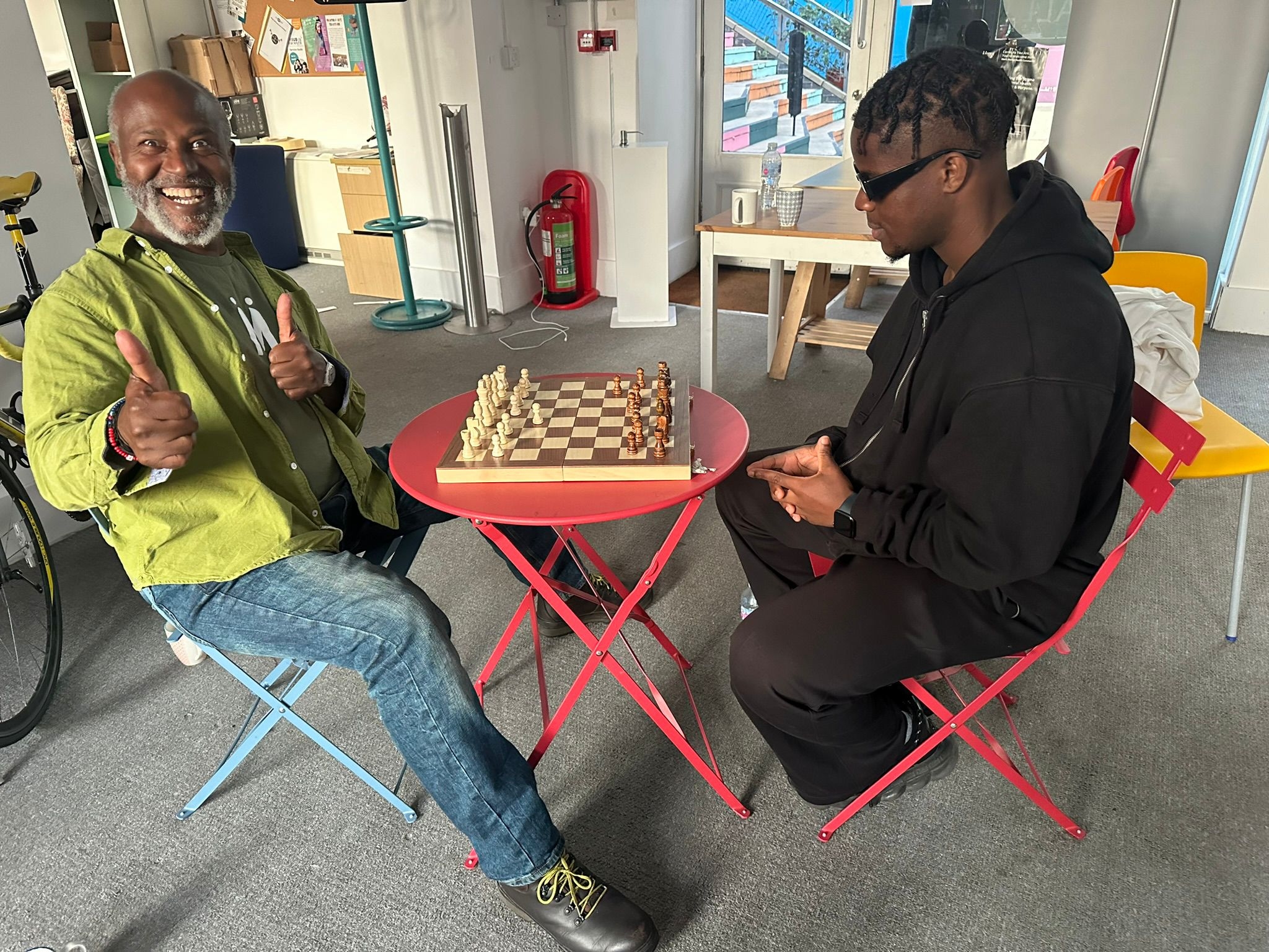 Men playing chess over warm drinks at Pawn Hub